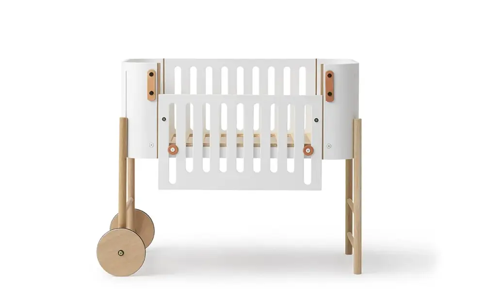 Weißes Babybett oder Beistellbett mit Holzbeinen und Rädern Weißes Babybett oder Beistellbett mit Holzbeinen und Rädern