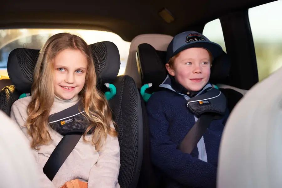 Zwei Kinder sitzen sicher mit ihren Sicherheitsgurten auf dem Rücksitz. Beide sitzen bequem im BeSafe Flex FIX 2.