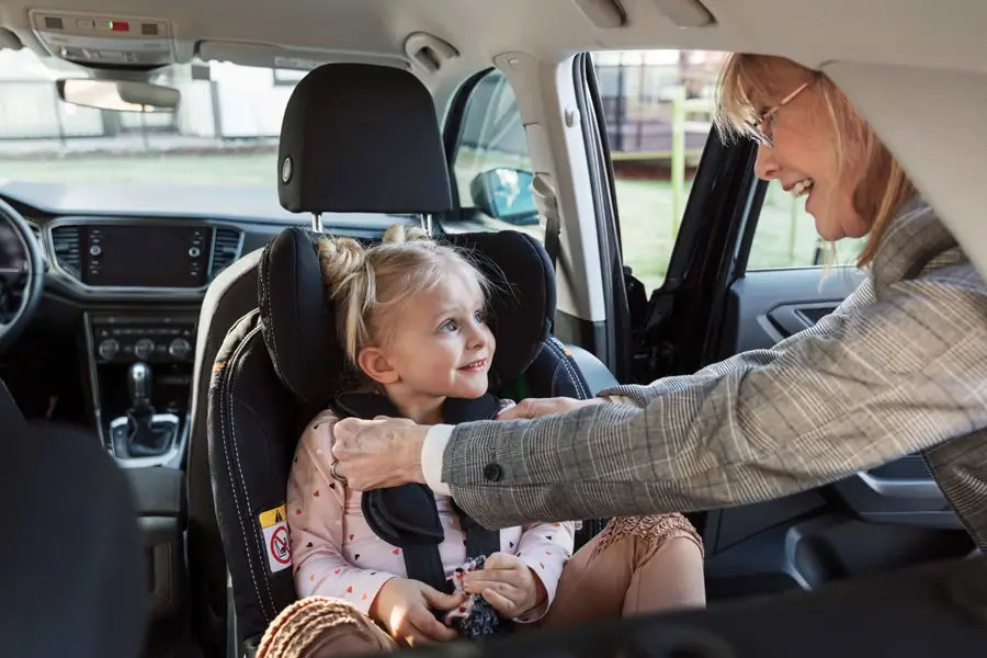 Eine Frau schnallt ein Kind sicher im BeSafe iZi Modular A X1 i-Size-Autositz im Auto an. Eine Frau schnallt ein Kind sicher im BeSafe iZi Modular A X1 i-Size-Autositz im Auto an.