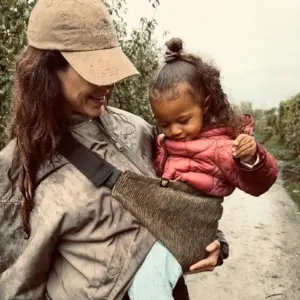 Eine Frau mit einer Wildride Trage aus Cord in Olivgrün.