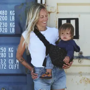 Eine Frau mit einer stylischen Wildride Kindertrage mit Animal Print